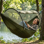 Camping hammock with mosquito net in use — person relaxing outdoors