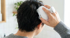 Rechargeable scalp massager in use on scalp